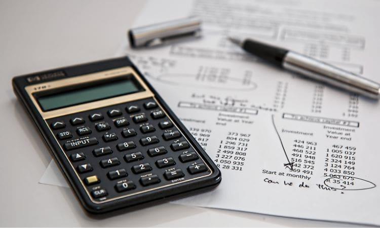 Calculatrice et stylo posés sur un document financier