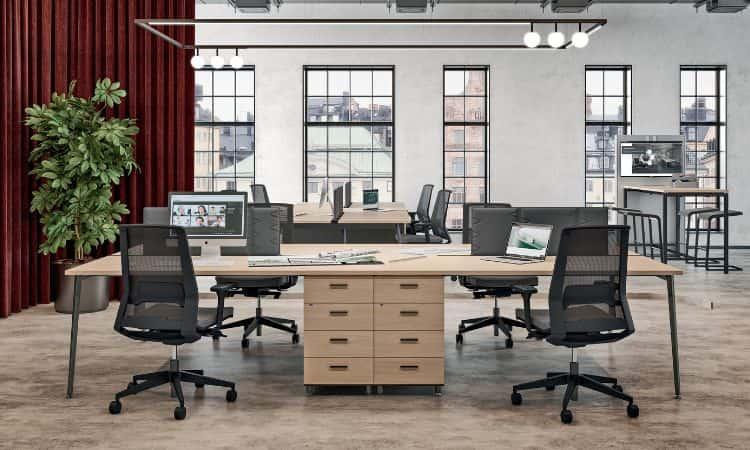 Open space avec bureaux bench en bois, fauteuils noirs et rideau rouge