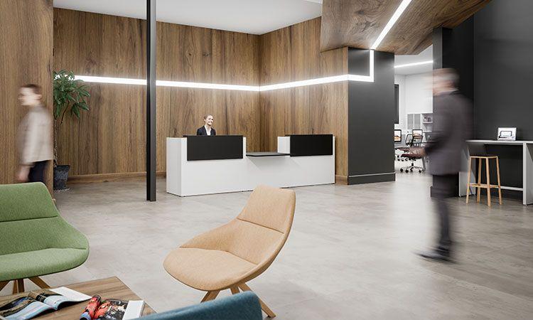 Hall d\'accueil avec banque bois et blanc, fauteuils lounge et mur en bois
