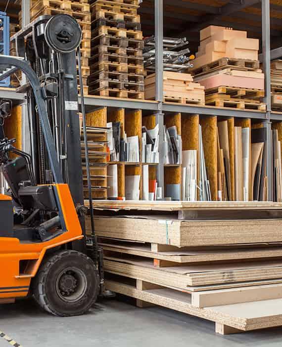 Chariot élévateur manipulant des palettes de bois dans un entrepôt