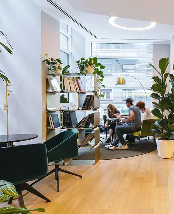 Espace lounge végétalisé avec fauteuils et bibliothèque