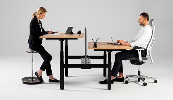 Bureau assis-debout partagé avec deux personnes, l\'une debout, l\'autre assise