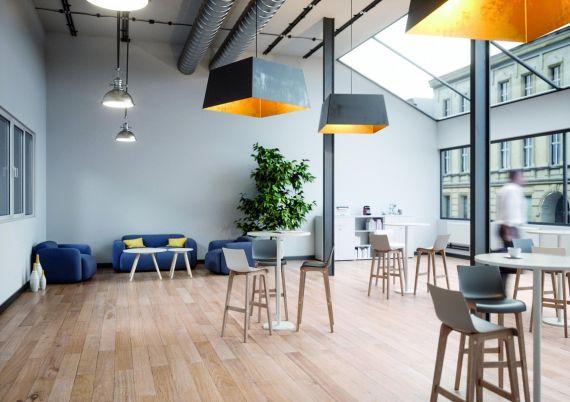 Espace de coworking lumineux avec tabourets, suspensions et canapés
