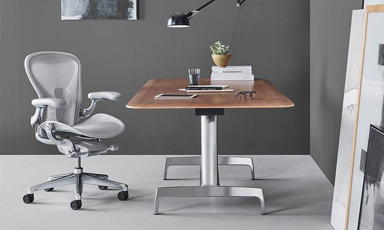 Fauteuil de bureau Aeron gris devant un bureau en bois