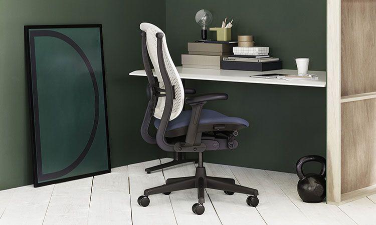 Fauteuil ergonomique Celle gris devant un bureau mural, mur vert