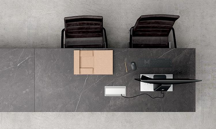 Bureau épuré gris avec fauteuils et un colis, vue de dessus
